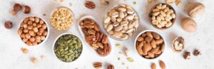 cropped 120687531 various nuts in bowls on white background top view banner nuts assortment pecans hazelnuts walnuts p